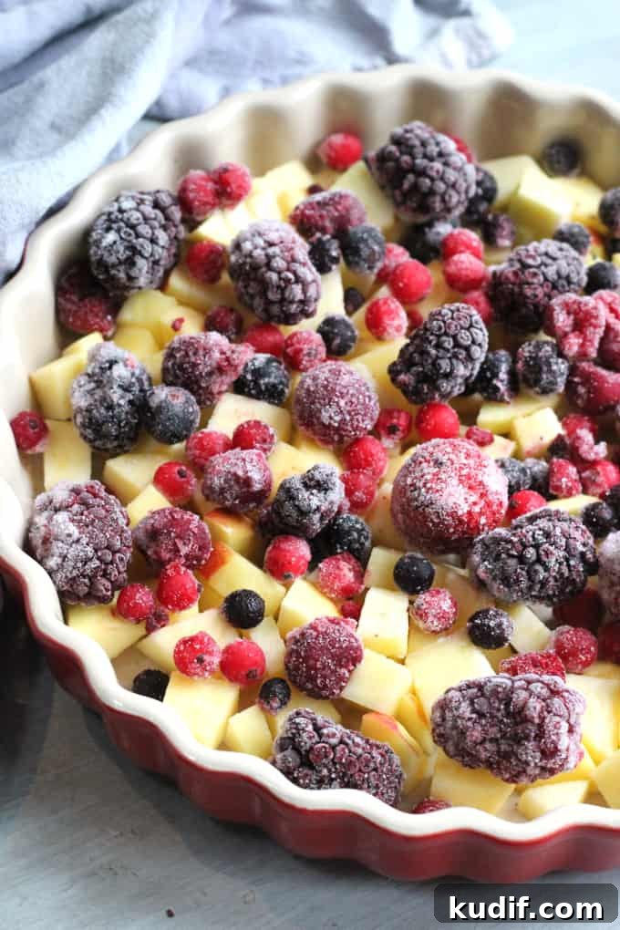 frozen strawberries, raspberries, blackberries, blackcurrants and redcurrants in the red ovenproof dish