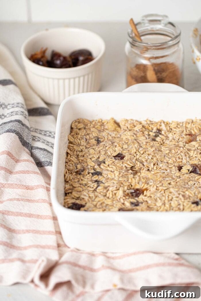 Raw oatmeal dough with banana and dates in a baking pan.