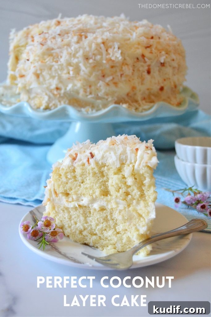 Ultimate Coconut Layer Cake Recipe for Moist, Fluffy Slices 2 coconut layer cake slice on a white plate with flowers and a fork
