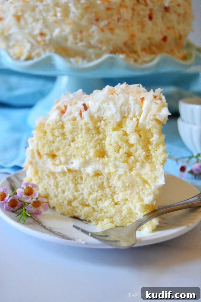 Ultimate Coconut Layer Cake Recipe for Moist, Fluffy Slices 7 coconut layer cake with a fork on a plate