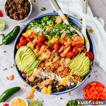 Finished healthy 7 layer salad bowl garnished with queso and avocado slices in large bowl.
