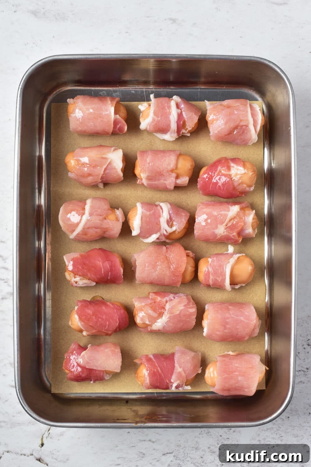 pigs in a blanket ready for oven on baking sheet, overhead view