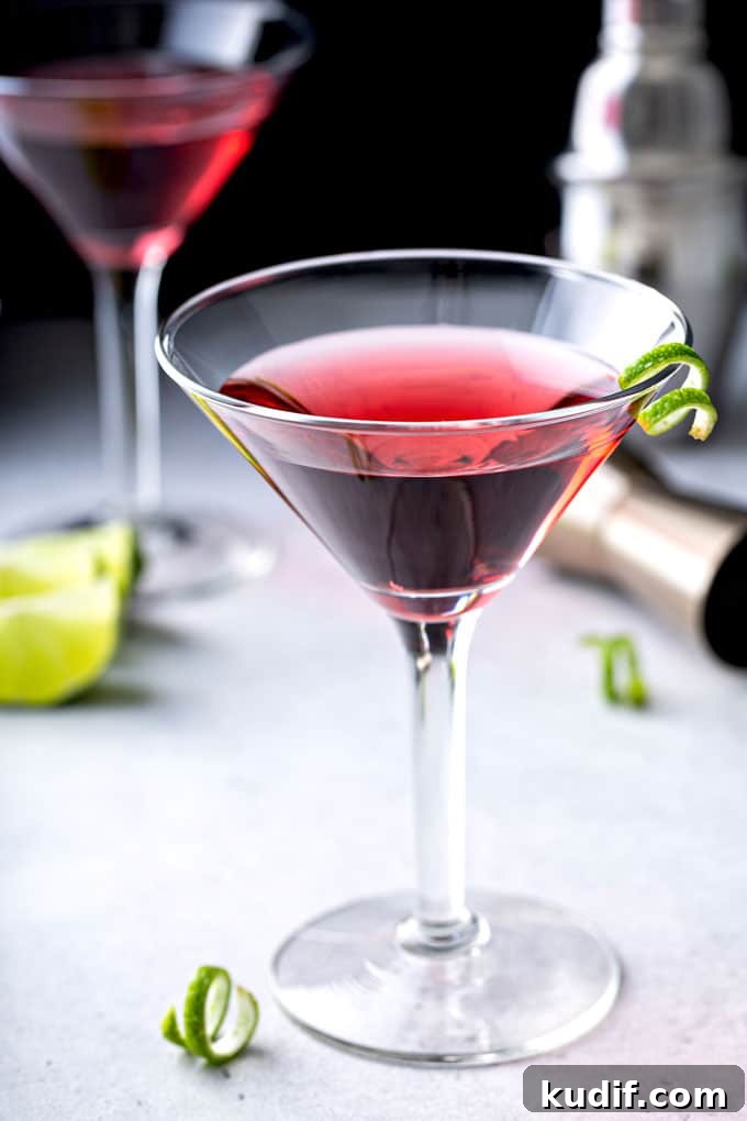Classic Cosmopolitan Cocktail Recipe: How to Mix the Perfect Cosmo 2 A martini glass filled with cosmopolitan cocktail martini on a light surface