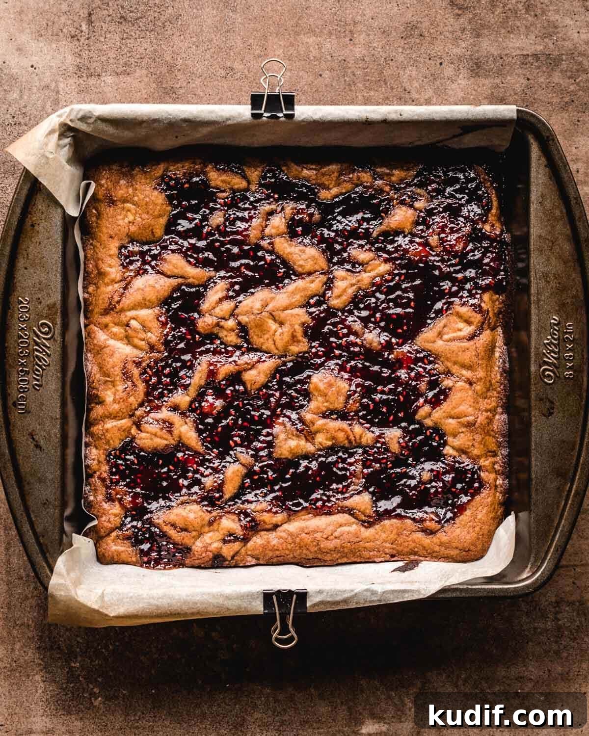 White Chocolate Raspberry Blondies with Tangy Fruit Swirls 12 Freshly baked white chocolate and raspberry blondies in the baking pan.