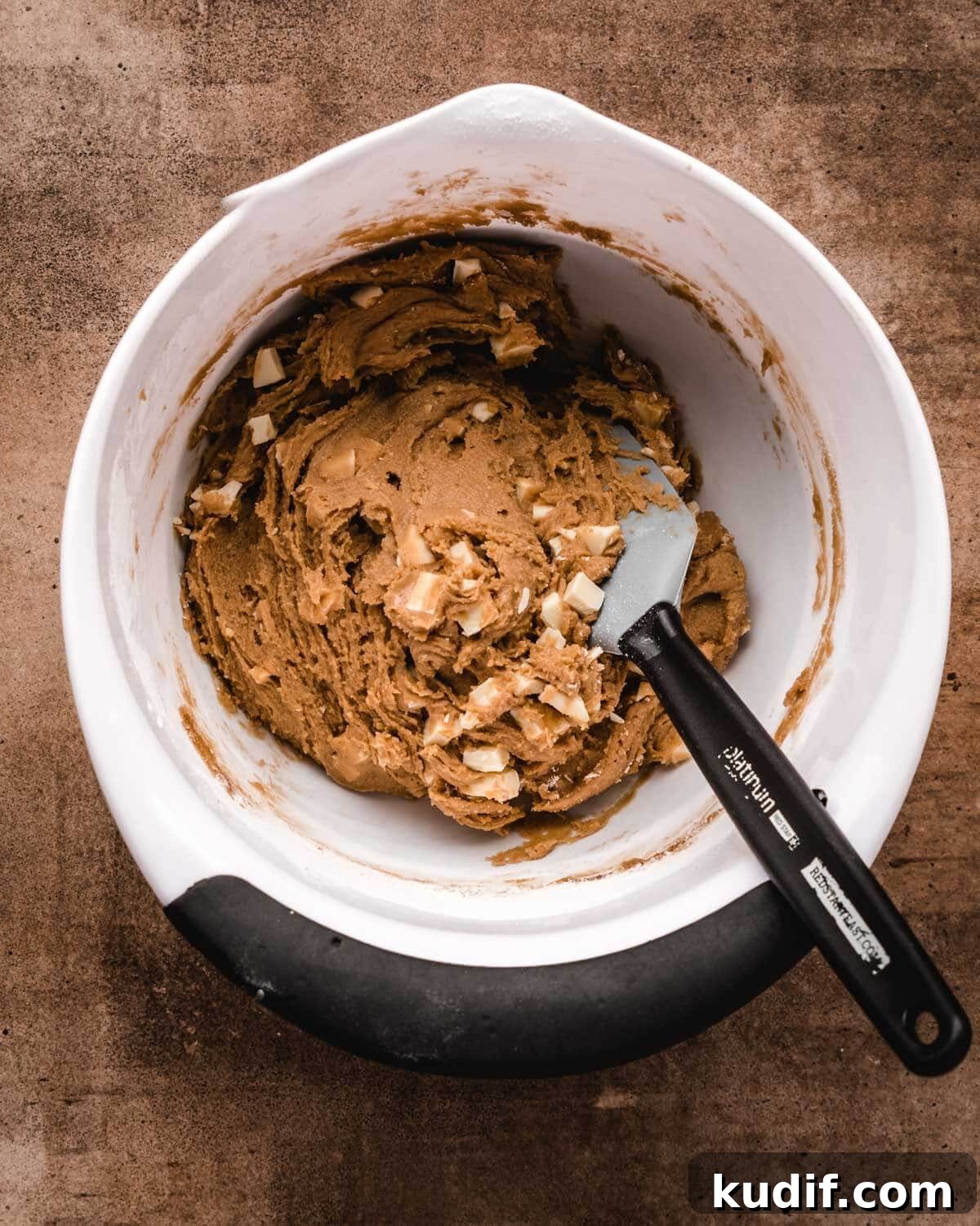 White Chocolate Raspberry Blondies with Tangy Fruit Swirls 8 White chocolate chunks mixed into blondie batter in a mixing bowl.