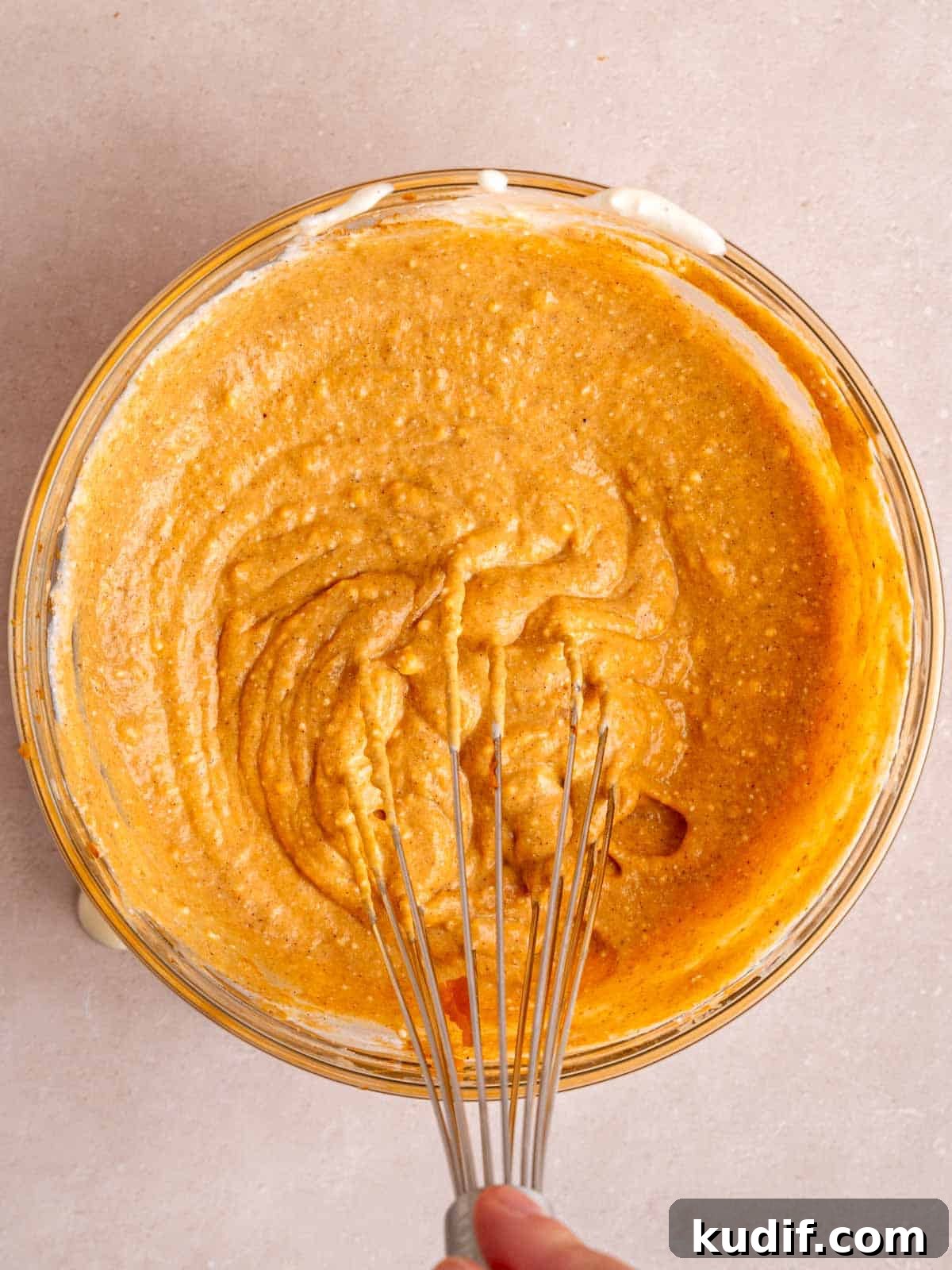 Pumpkin Cheesecake Bars Recipe for Fall Dessert Lovers 8 Pumpkin cheesecake filling in a bowl with a whisk.