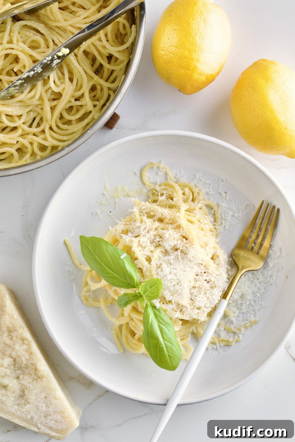 Creamy Lemon Butter Pasta Recipe (Pasta al Limone) 2 A plate of lemon pasta on the table next to some whole lemons and a dish of pasta to the side.