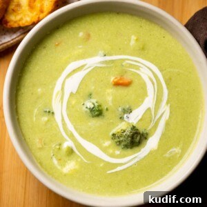 Cream-Free Broccoli Soup Recipe — Smooth, Light, and Flavorful 4 Healthy broccoli soup served in a white bowl with garlic bread on the side