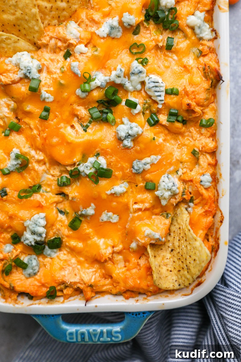 Lightened-Up Buffalo Chicken Dip Recipe for Game Day 8 Cheesy lightened-up buffalo chicken dip in a casserole dish topped with blue cheese crumbles and sliced green onion