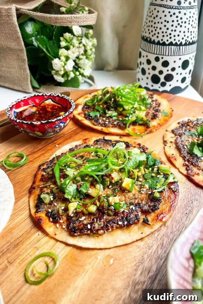Smash Shrimp Toast Tacos — Crispy Prawn Toast Taco Recipe 12 Dumpling taco on a wooden board, with more tacos in the background.