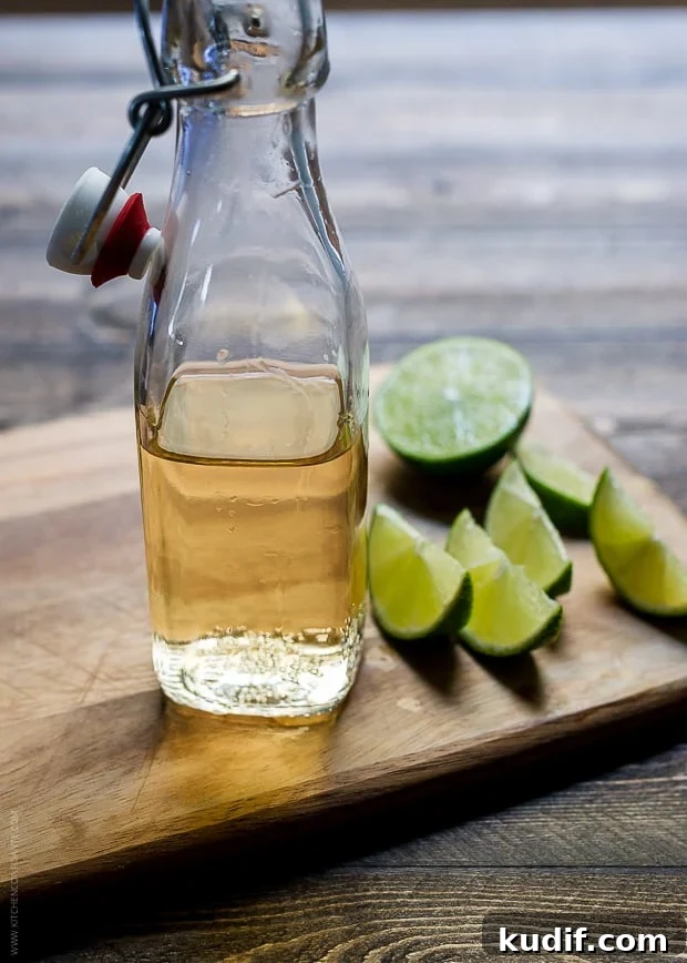 Pumpkin Spice Dark & Stormy Cocktail Recipe for Fall Nights 3 A glass bottle of ginger beer and slices of lime on a wooden surface.