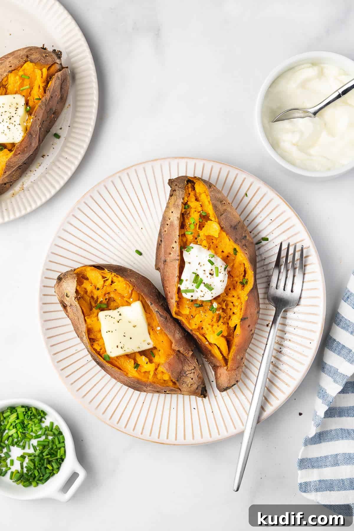 Slow Cooker Mashed Sweet Potatoes Recipe for Weeknight Meals 2 Overhead view of two slow cooker sweet potatoes with butter, sour cream, and chives.