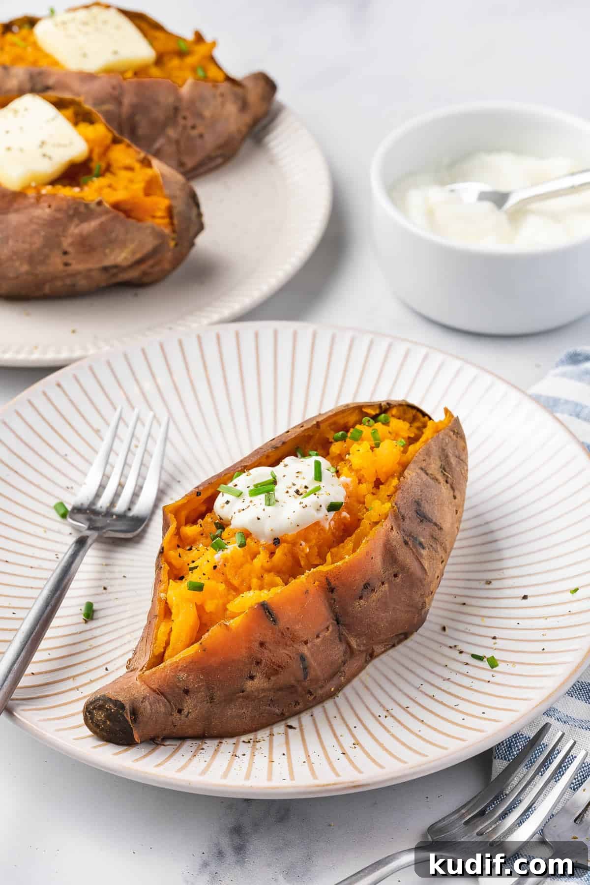Slow Cooker Mashed Sweet Potatoes Recipe for Weeknight Meals 10 A plate with a slow cooker sweet potato with butter and chives on top.
