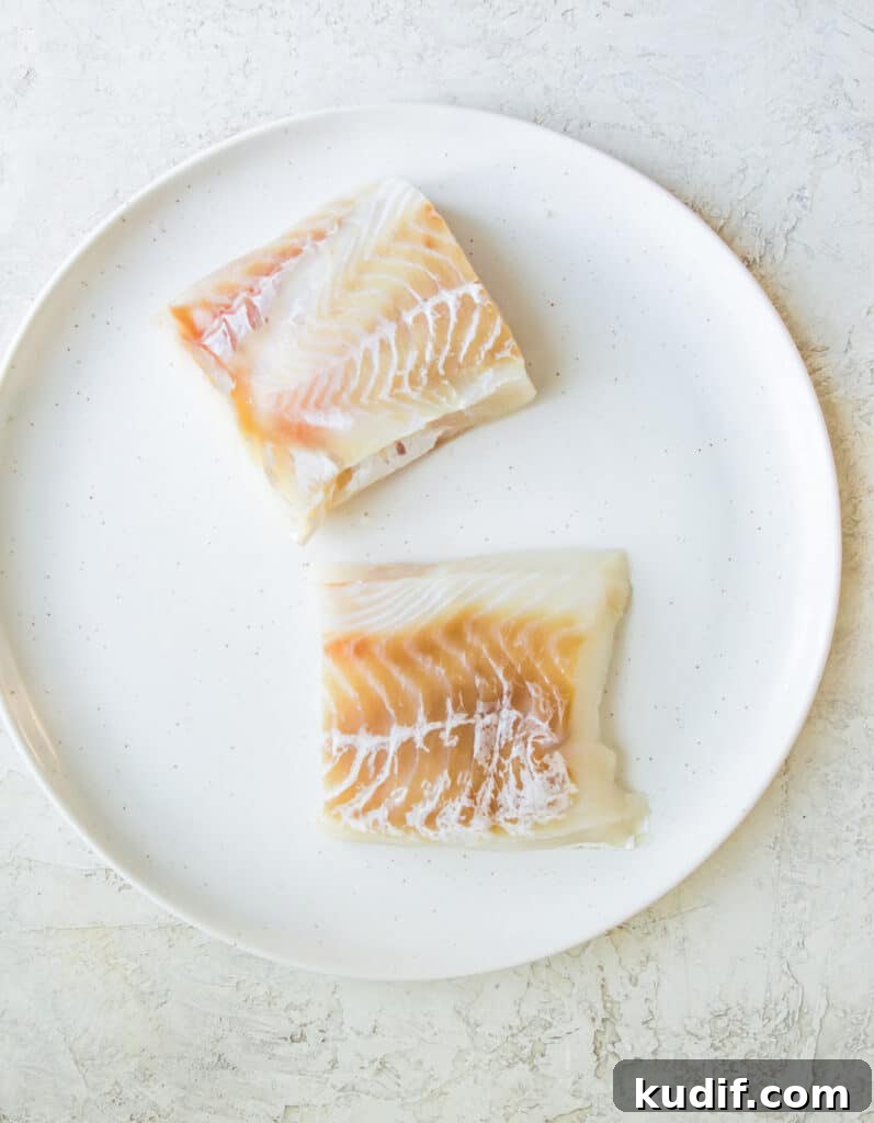 Two cod fillets on a plate.