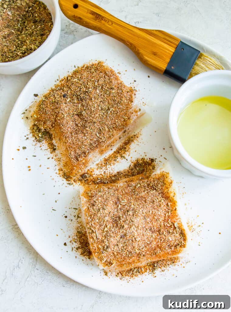 Two cod fillets coated with seasoning.