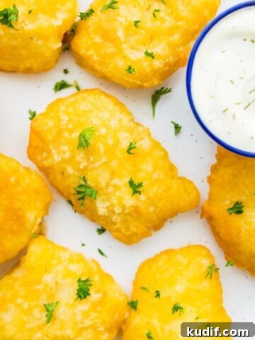 Cooked fish sticks on a plate garnished with fresh parsley.