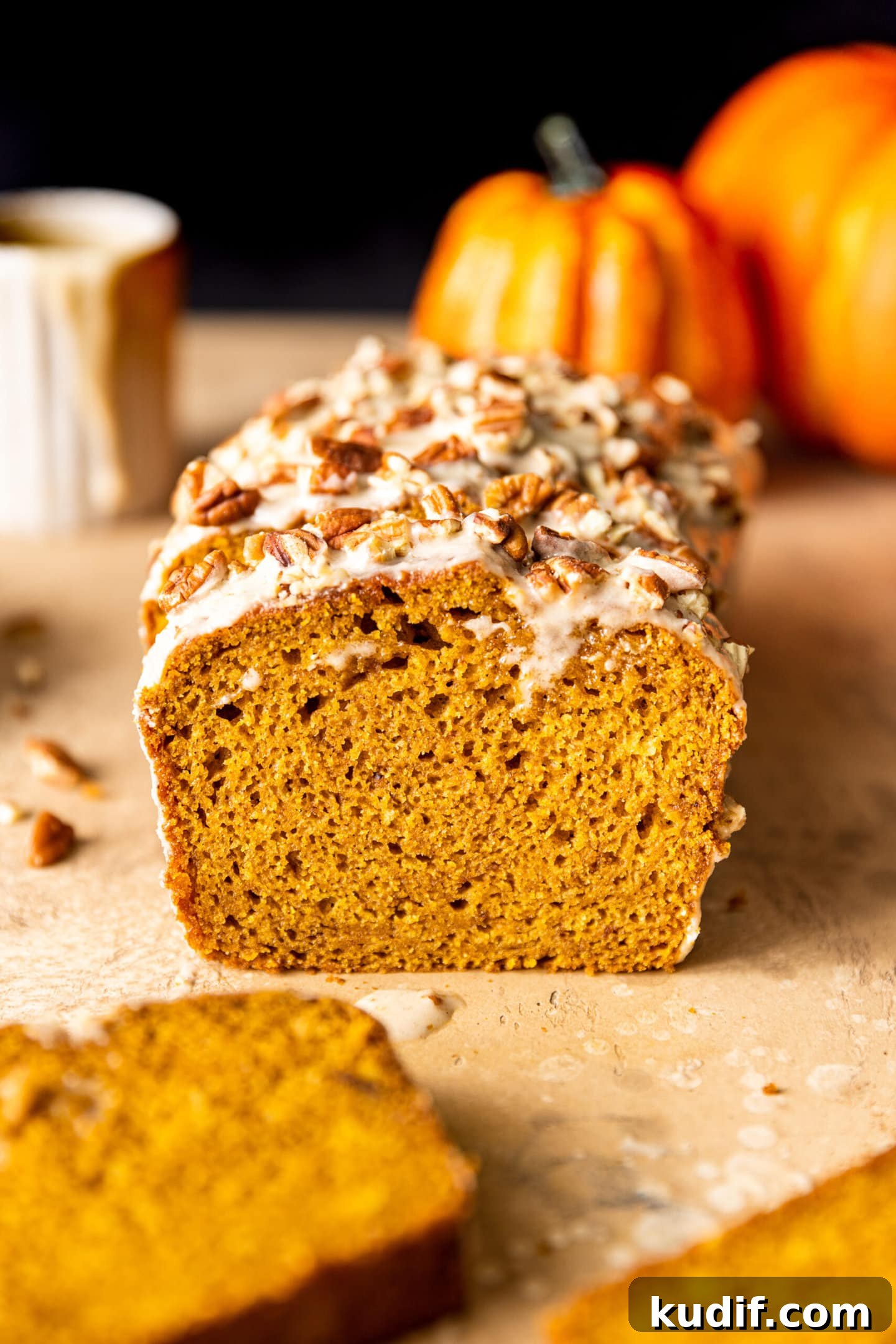 Maple-Glazed Pumpkin Bread Recipe for Fall Baking 2 Slices of Maple Glazed Pumpkin Bread with chopped pecans on top