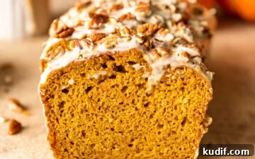 Maple-Glazed Pumpkin Bread Recipe for Fall Baking 11 Slices of Maple Glazed Pumpkin Bread with chopped pecans on top