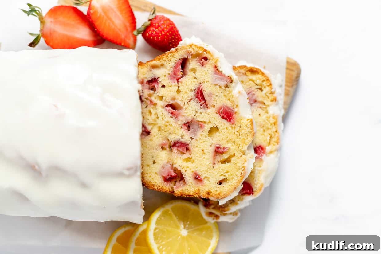 Quick Berry Desserts to Satisfy Sweet Cravings Fast 14 A slice of strawberry bread with lemon icing on a cutting board.