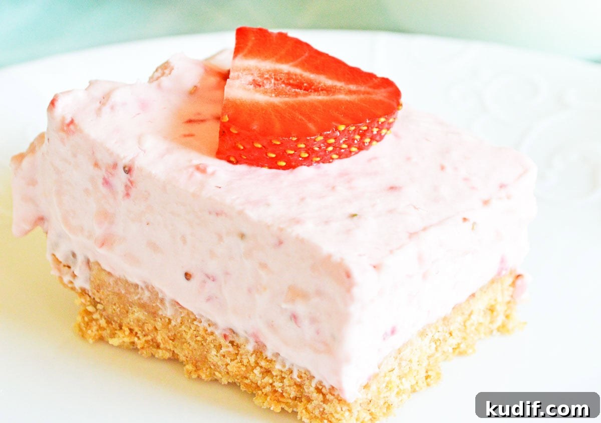 Quick Berry Desserts to Satisfy Sweet Cravings Fast 4 A slice of strawberry cheesecake on a white plate, topped with a strawberry piece, with whole strawberries and a glass of milk in the background.