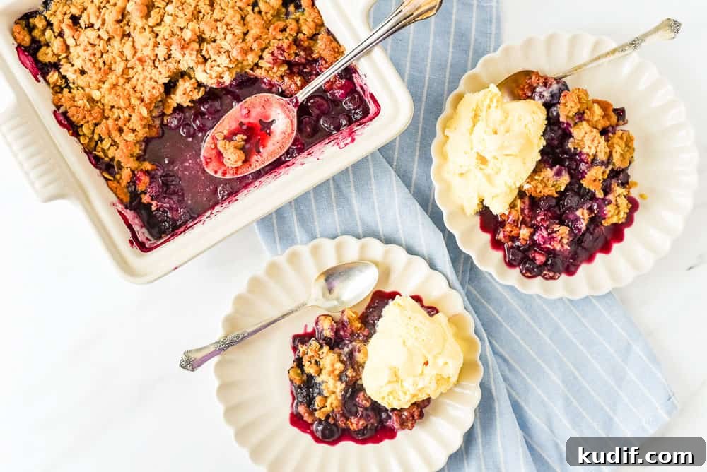 Quick Berry Desserts to Satisfy Sweet Cravings Fast 5 Blueberry crisp in a baking pan, with scoops plated on small dishes and topped with vanilla ice cream.