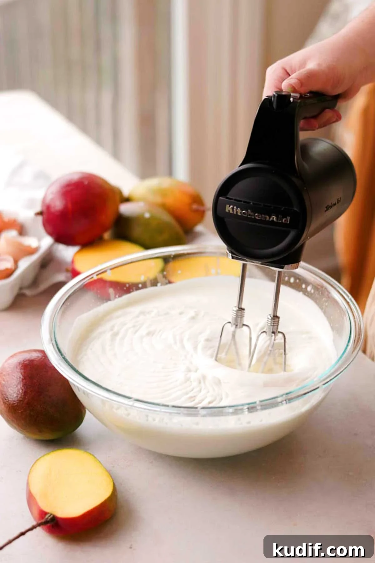 Mango Crepe Cake Recipe with Homemade Crepes Made from Scratch 11 whipping cream in a glass bowl with an electric mixer