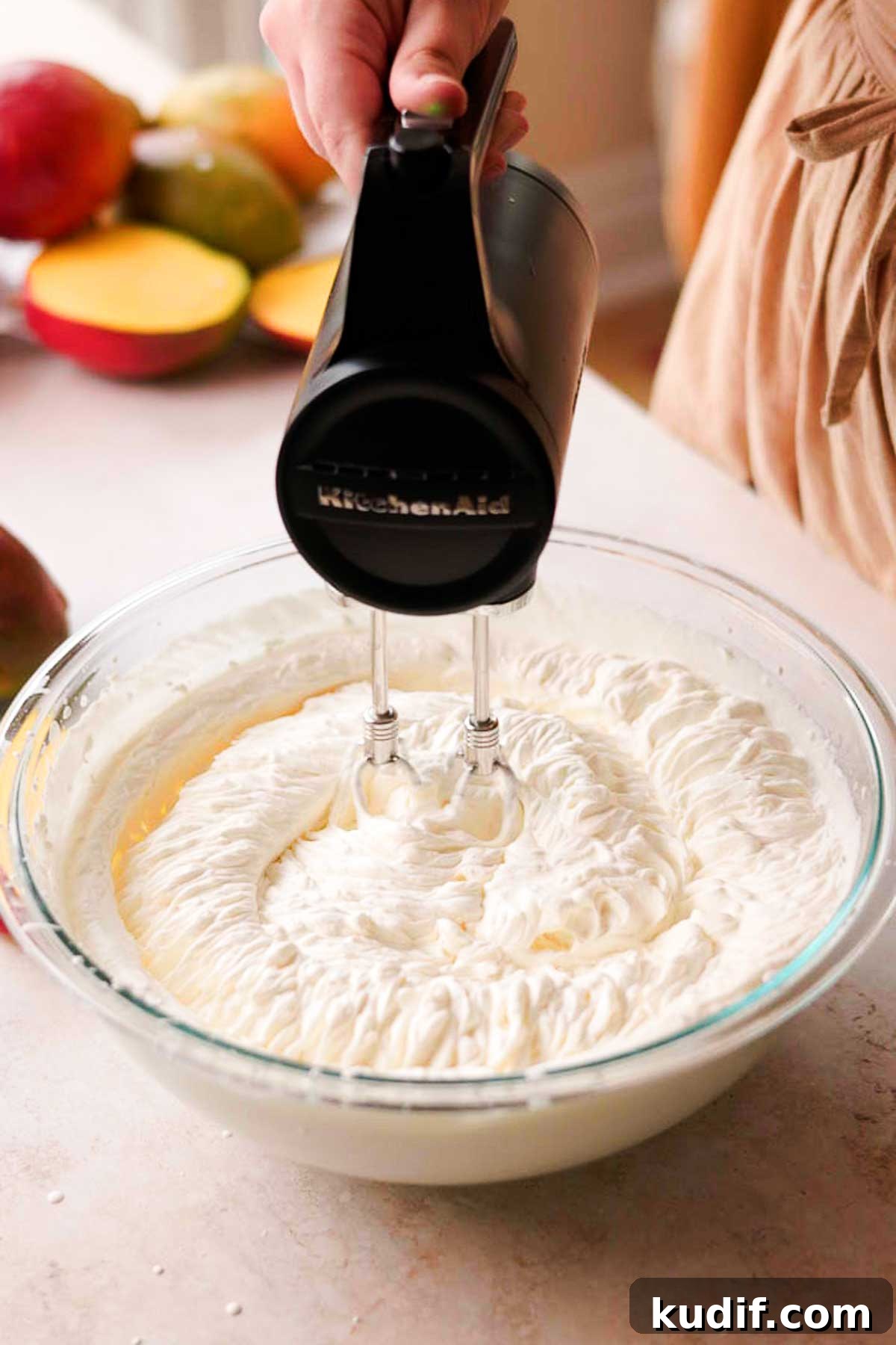 Mango Crepe Cake Recipe with Homemade Crepes Made from Scratch 12 mixing whipped cream with mascarpone cheese in a glass bowl with a hand held electric mixer