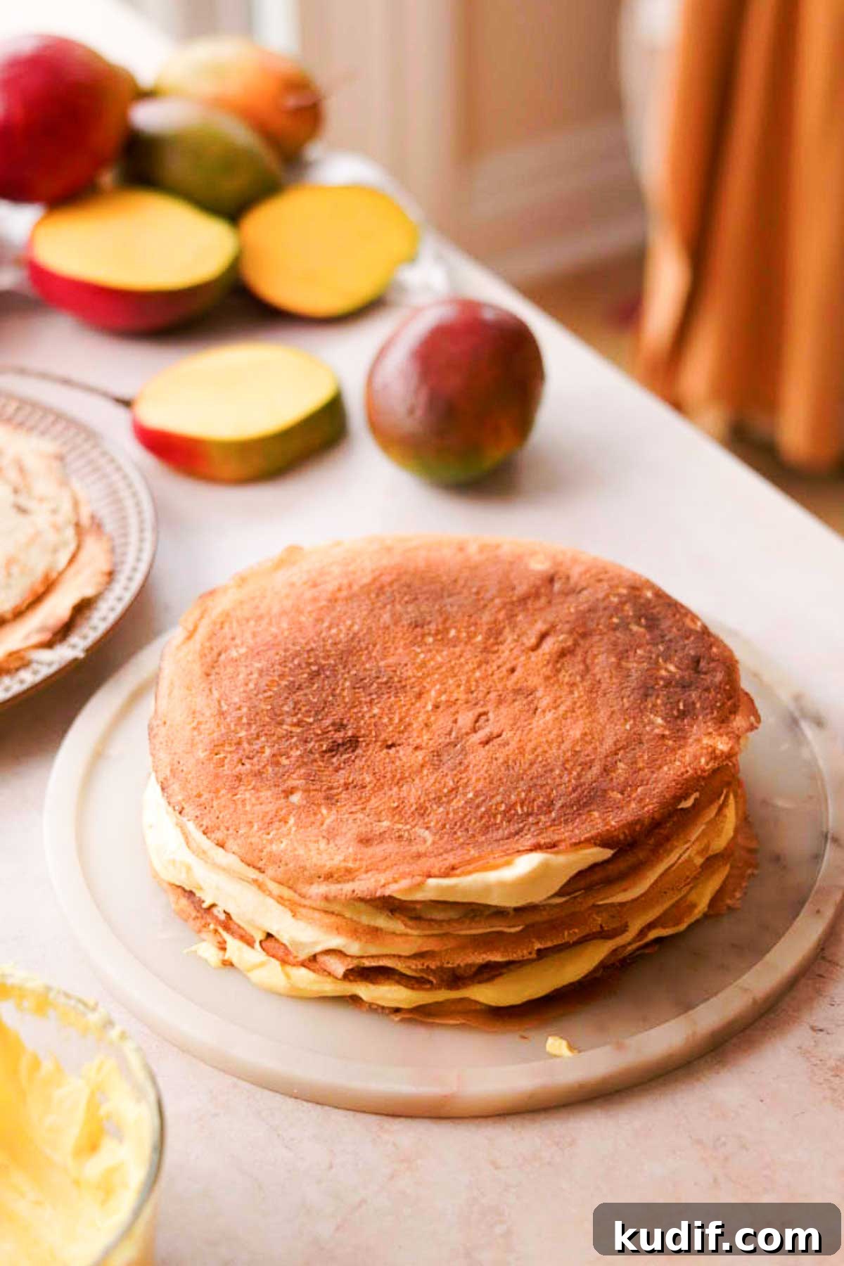 Mango Crepe Cake Recipe with Homemade Crepes Made from Scratch 15 layering the mango cake with crepes and cream in between