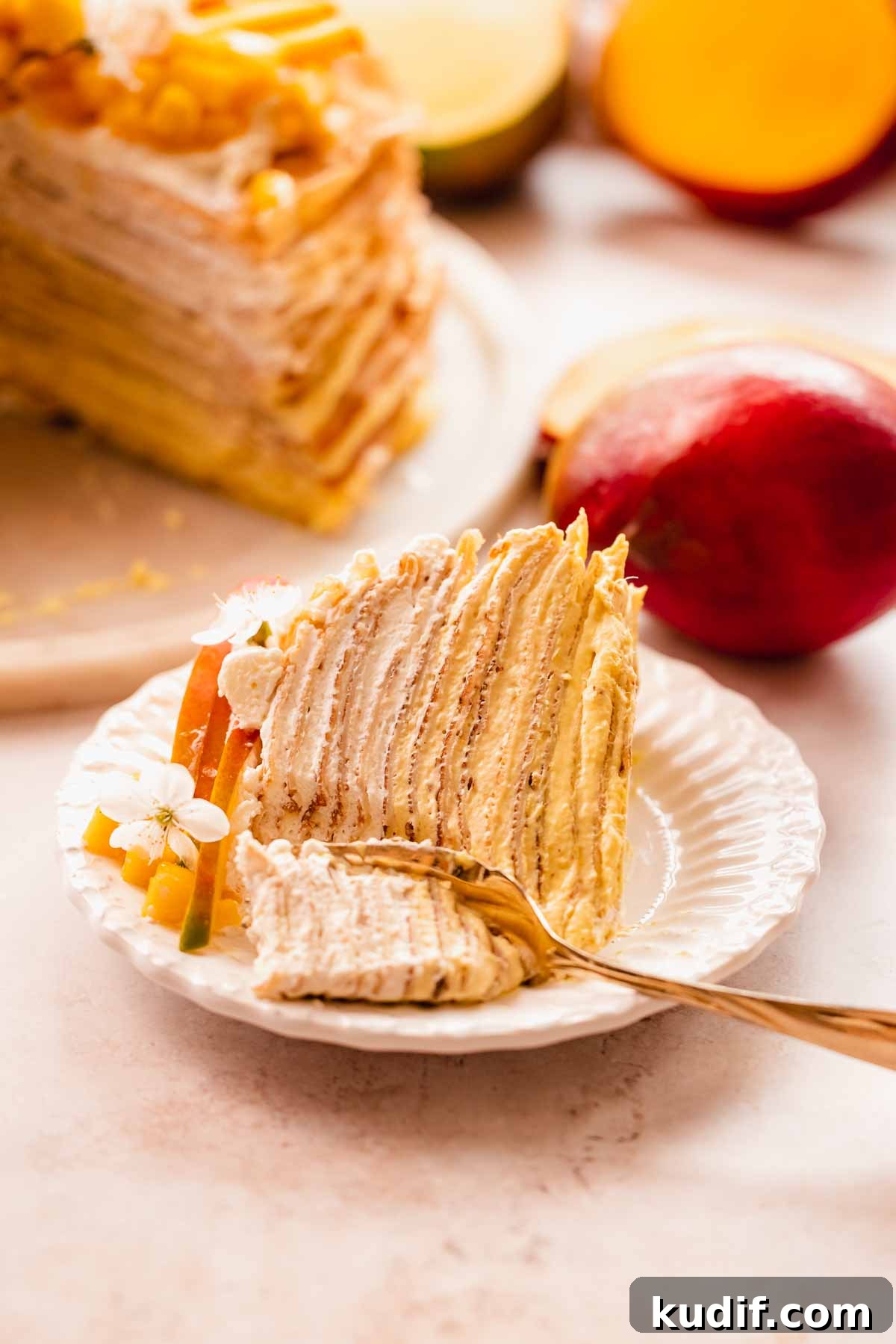 Mango Crepe Cake Recipe with Homemade Crepes Made from Scratch 20 mango crepe cake slice laying on its side with a fork cutting a piece