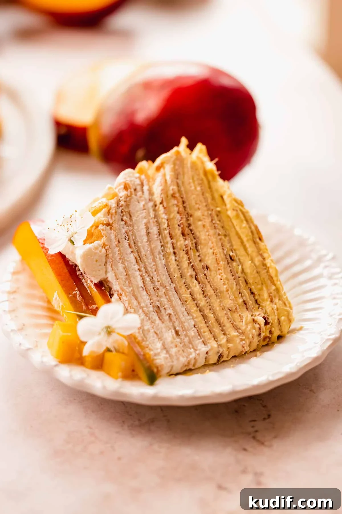 Mango Crepe Cake Recipe with Homemade Crepes Made from Scratch 3 a close up shot of a mango crepe cake slice with the creamy layers