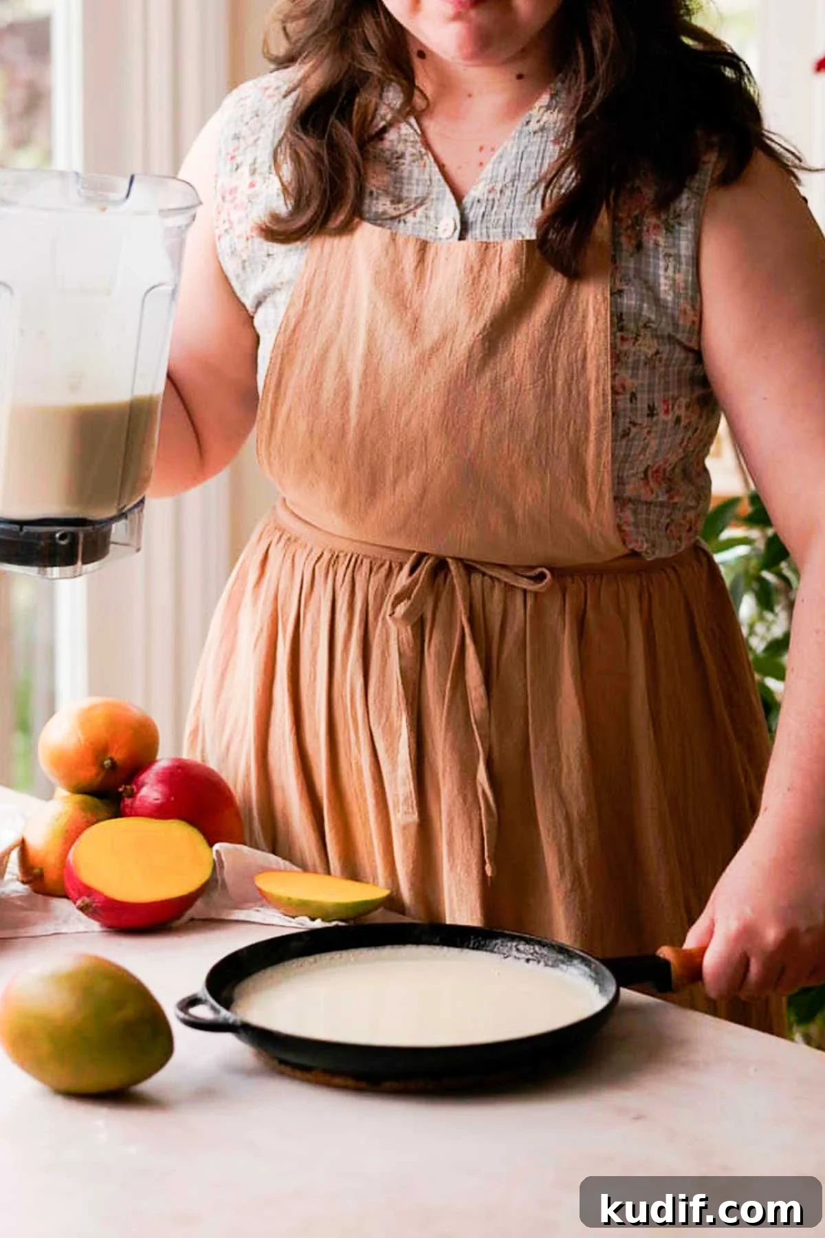 Mango Crepe Cake Recipe with Homemade Crepes Made from Scratch 7 pouring crepe batter onto a cast iron pan