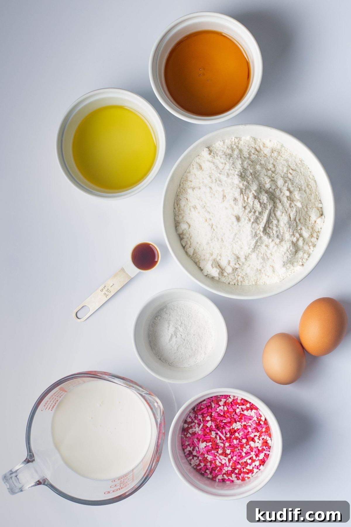 Ingredients measured in small white bowls on a white marble table. 