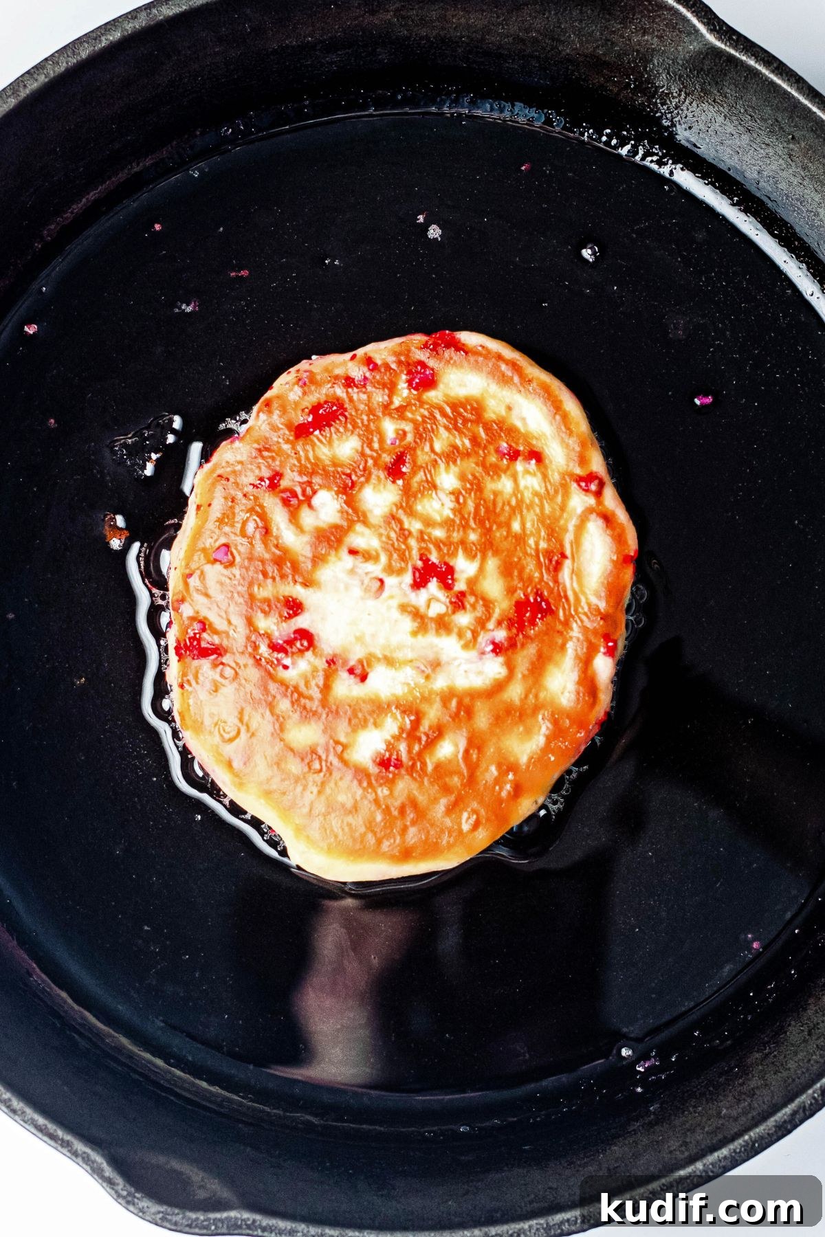 Golden pancake in a black skillet.