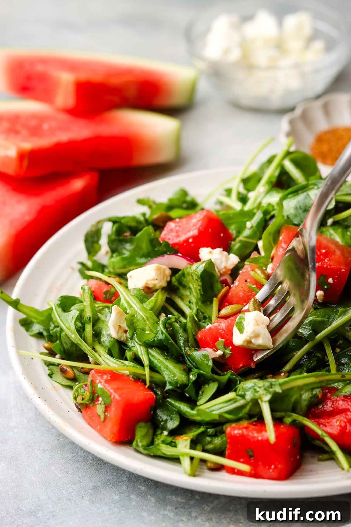Refreshing Mexican Watermelon & Jicama Salad Recipe 2 a plate of Mexican watermelon salad with watermelon slices shown in the background.