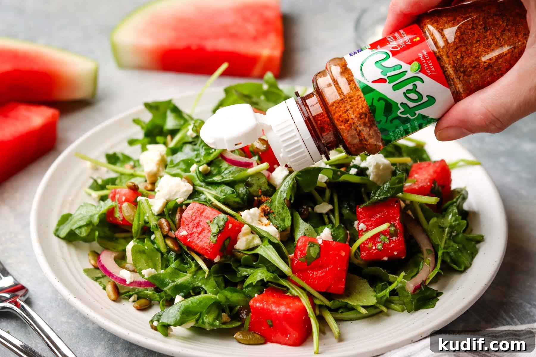 Refreshing Mexican Watermelon & Jicama Salad Recipe 4 sprinkling tajin on a plate of mexican watermelon salad