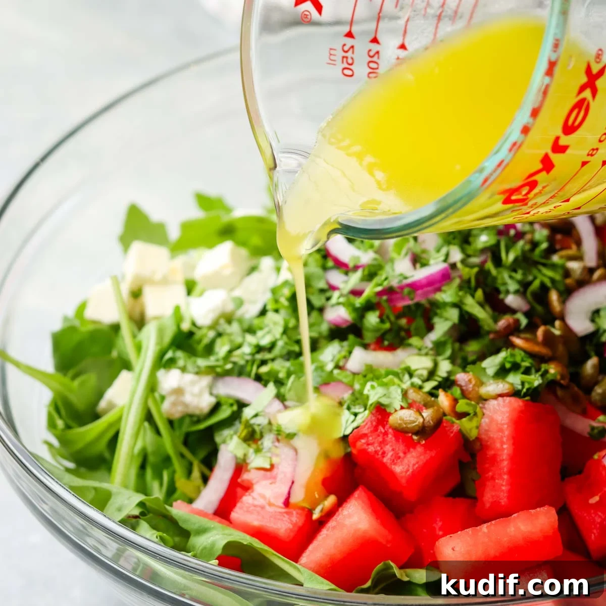 Refreshing Mexican Watermelon & Jicama Salad Recipe 9 adding dressing over the ingredients in the bowl