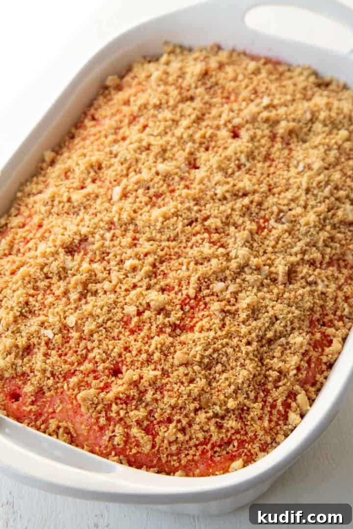 Strawberry Graham Poke Cake Recipe with Creamy Filling 13 graham cracker crumbs on top of a poke cake.