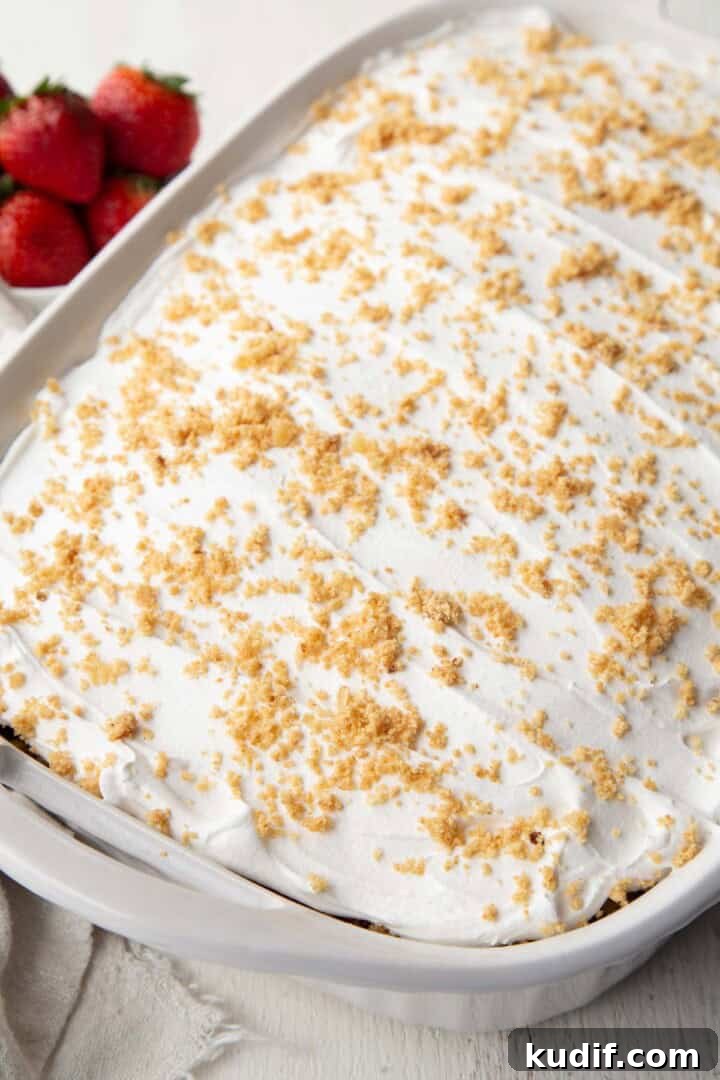 Strawberry Graham Poke Cake Recipe with Creamy Filling 14 whipped topping on a 13x9inch cake, topped with graham cracker crumbs.
