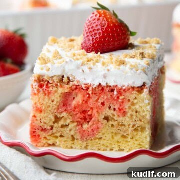 Strawberry Graham Poke Cake Recipe with Creamy Filling 16 yellow cake with strawberry jello poking through, topped with whipped topping, graham cracker crumbs, and a strawberry.
