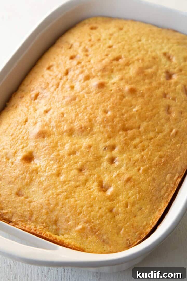 Strawberry Graham Poke Cake Recipe with Creamy Filling 9 baked yellow cake in a baking dish.