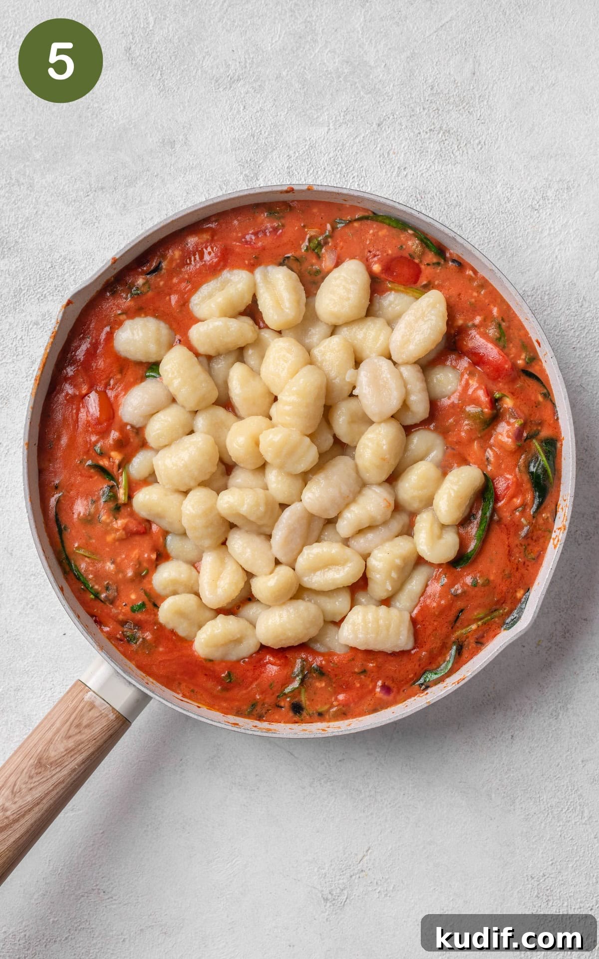 Gnocchi in red sauce in a skillet.