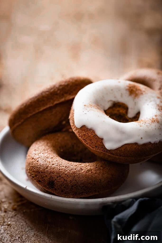 Baked Gingerbread Donuts with Vanilla Glaze 2 Stack of three donuts, one with icing on a plate.