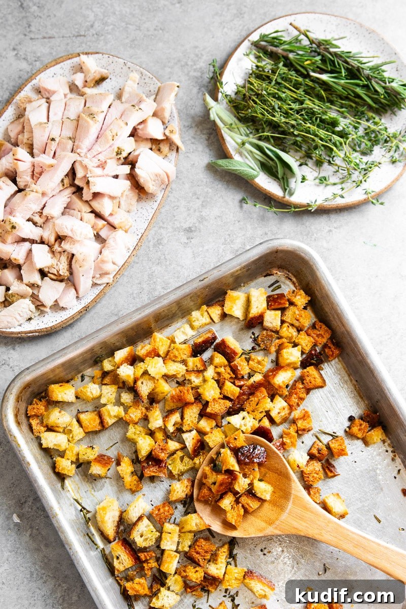 Hearty Turkey, White Bean, and Kale Soup Recipe 5 Toasted bread pieces on a baking sheet, cooked turkey, fresh herbs.
