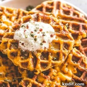 Cheesy Potato Waffles - Delicious, cheesy, and savory waffles prepared with leftover mashed potatoes and cheddar cheese. Crispy on the outside and fluffy on the inside, these potato waffles not only taste amazing, but they are a super fun meal to serve to your family. 