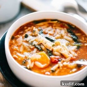 A bowl of leftover turkey soup with orzo and spinach.