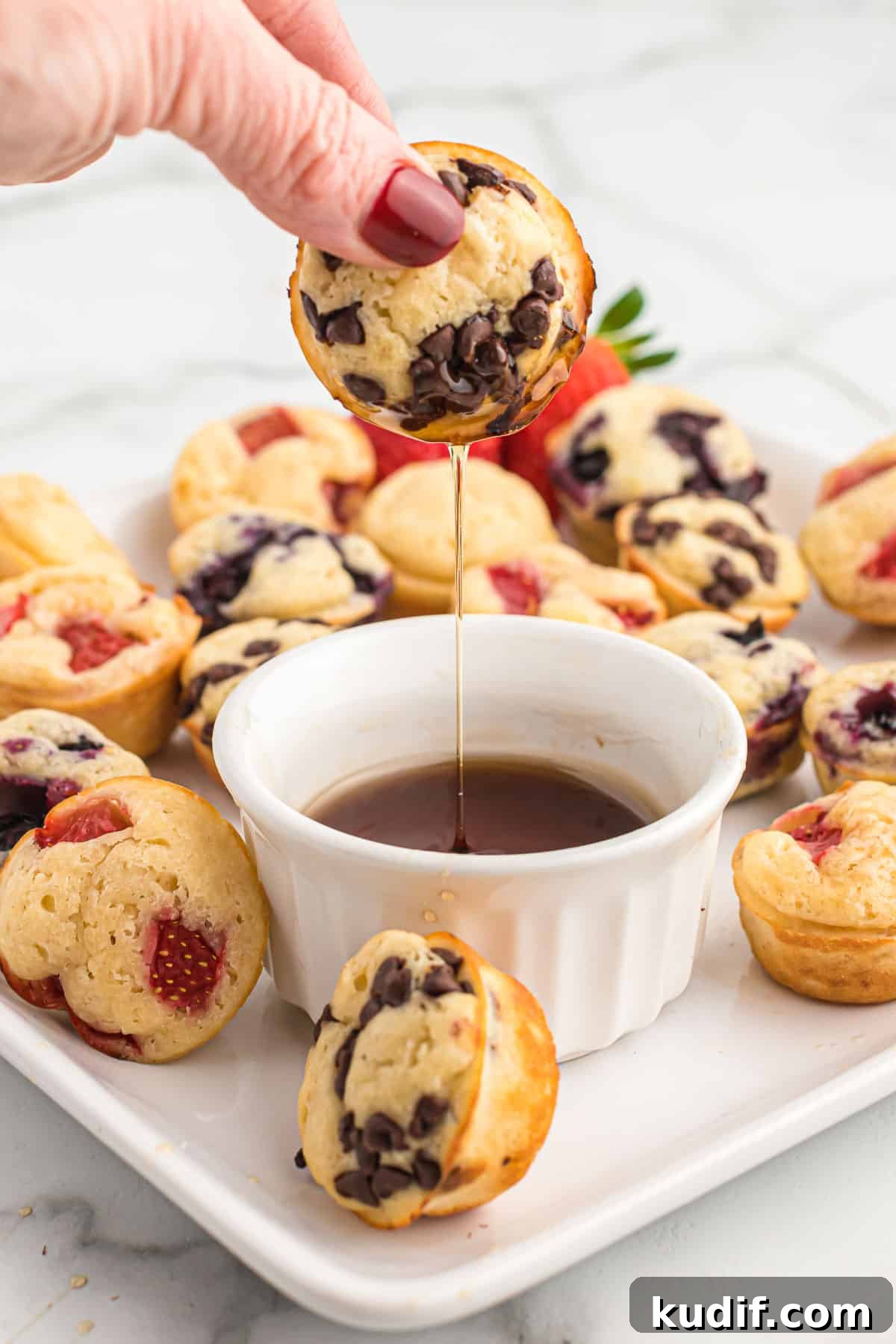Fluffy Pancake Mini Muffins: Bite-Sized Breakfast Treats 13 dipping a mini muffin in syrup