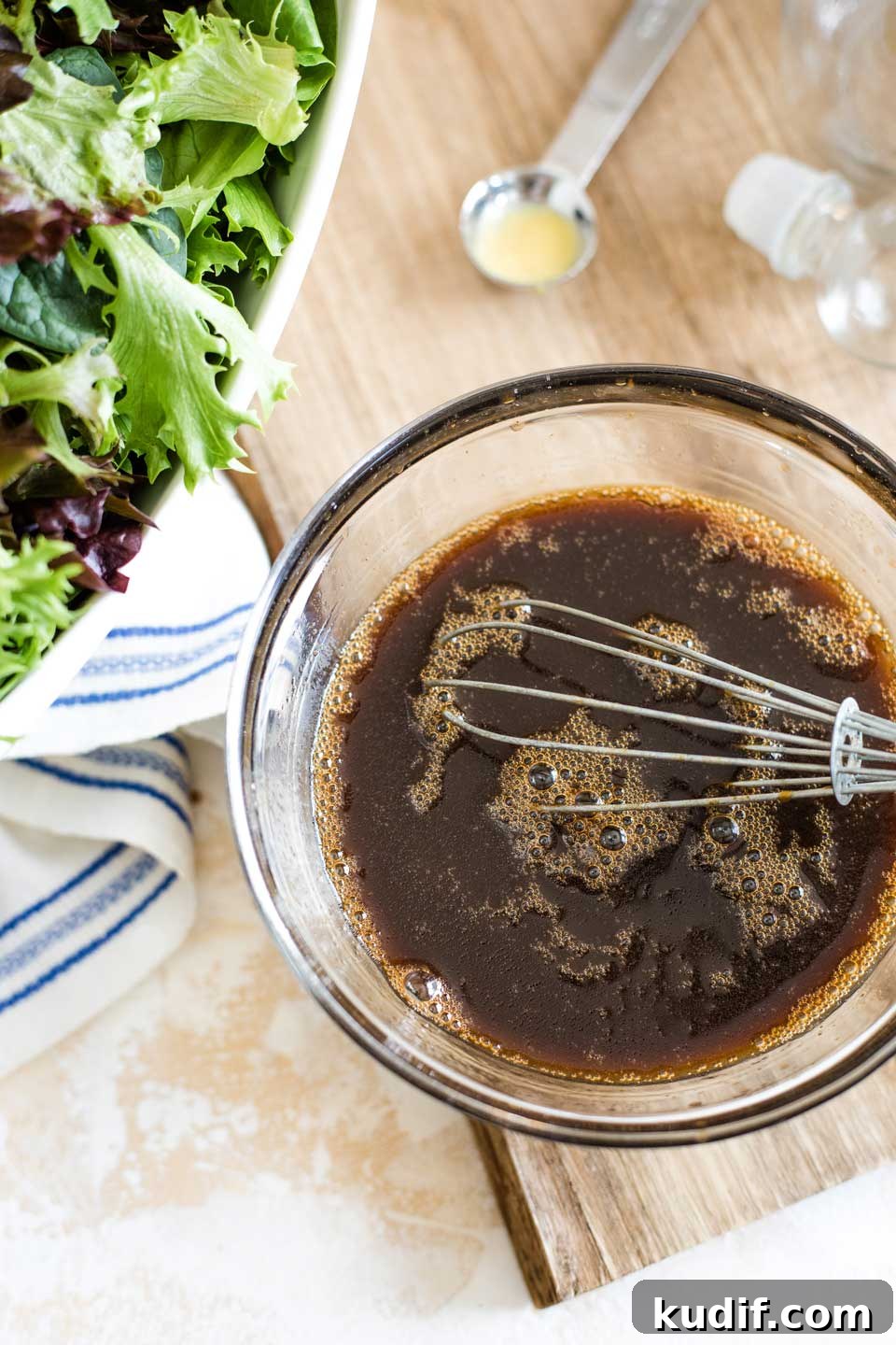 How to Make Balsamic Vinaigrette overhead of mixing bowl with vinaigrette recipe ingredients being whisked together