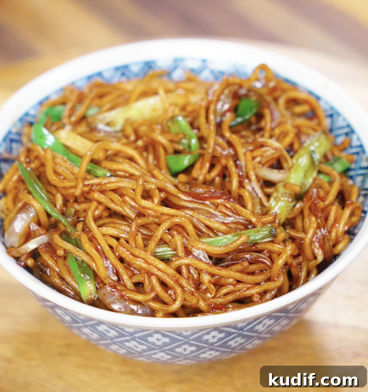 Authentic Chicken Chow Mein Recipe: Quick Stir-Fry Noodles 2 A bowl of chow mein with glossy noodles, stir-fried onions, scallions, and cabbage, ready to eat.