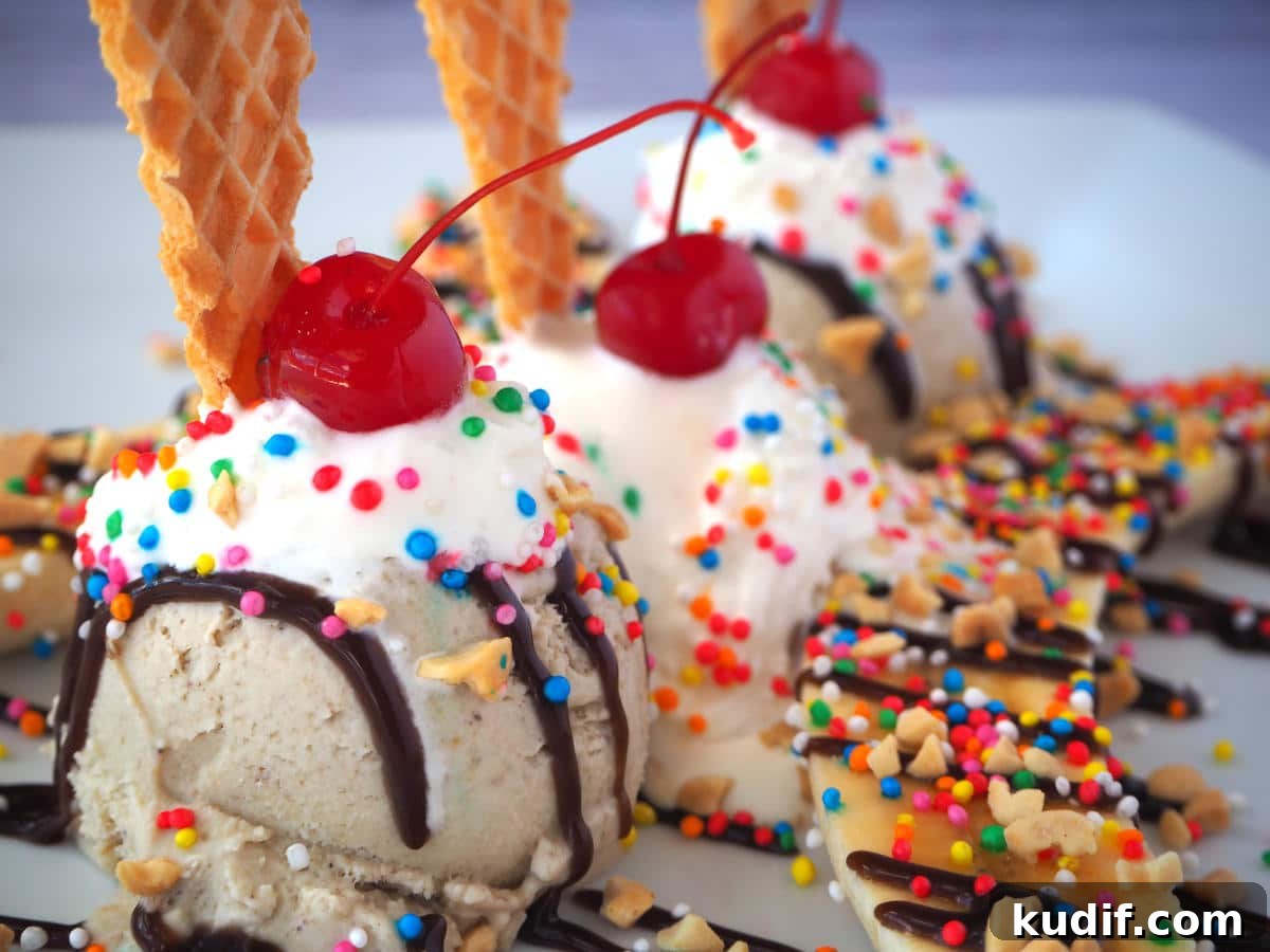 Classic Banana Split Recipe | Step-by-Step Dessert Guide 3 Close up diagonal view of banana split with scoops of banana and vanilla ice cream, sliced banana, chocolate sauce, whipped cream, nuts, sprinkles, cherries and a wafer.