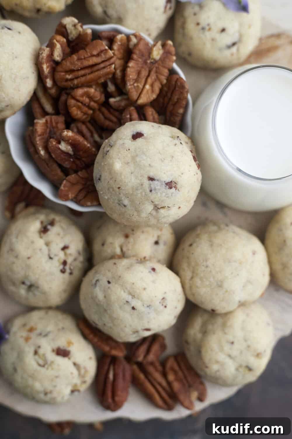 overhead image of baked pecan Sandies surrounded by pecans